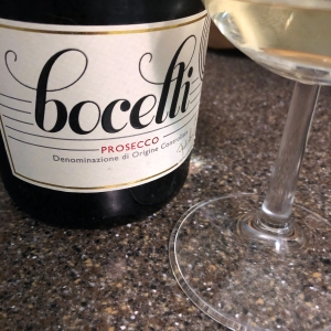 A bottle of Bocelli Prosecco and the base of a wine glass